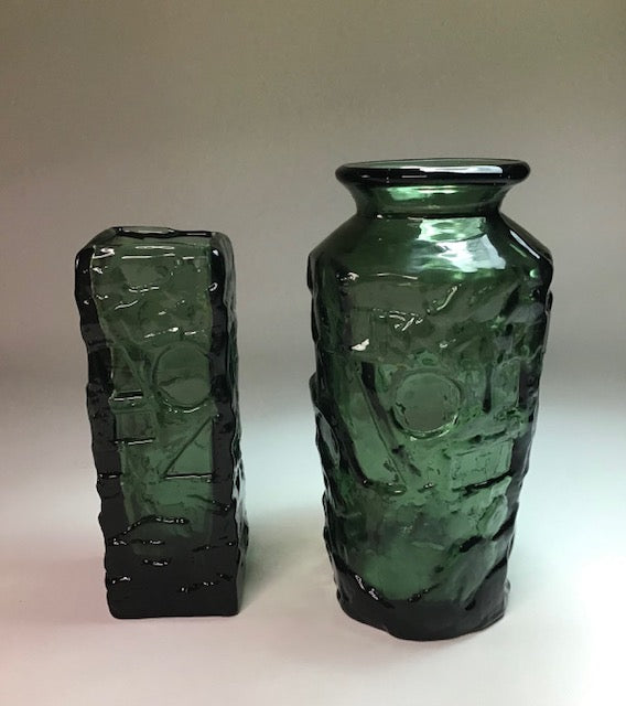 Two green glass vases with textured surface on a white background