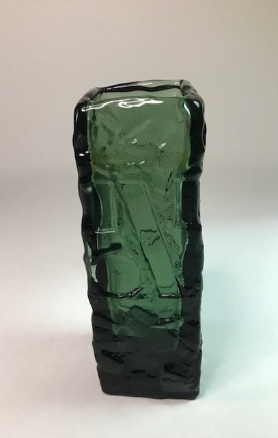 Green glass vase with textured surface on a white background