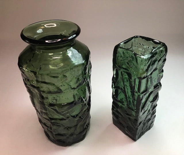 Two green textured vases on a light background