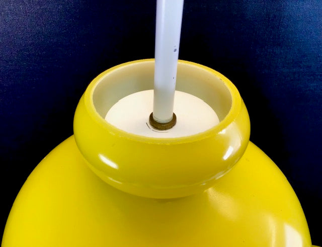 Yellow lampshade with a white core against a dark blue background
