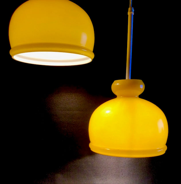 Two yellow pendant lights on a dark background