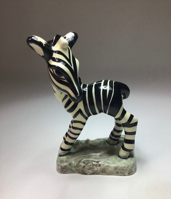 Ceramic zebra figurine on a gray background