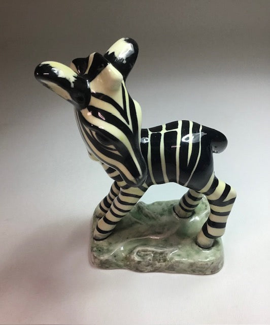 Ceramic zebra figurine on a plain background