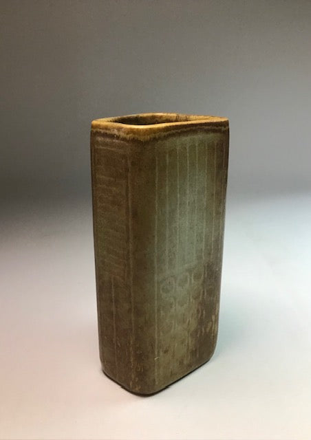 Rectangular ceramic vase with textured surface on a gradient background