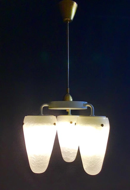 Vintage-style pendant light with frosted glass shades on a dark background
