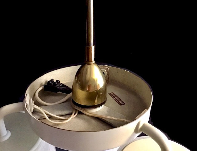 Close-up of a ceiling light fixture with a gold bulb on a black background