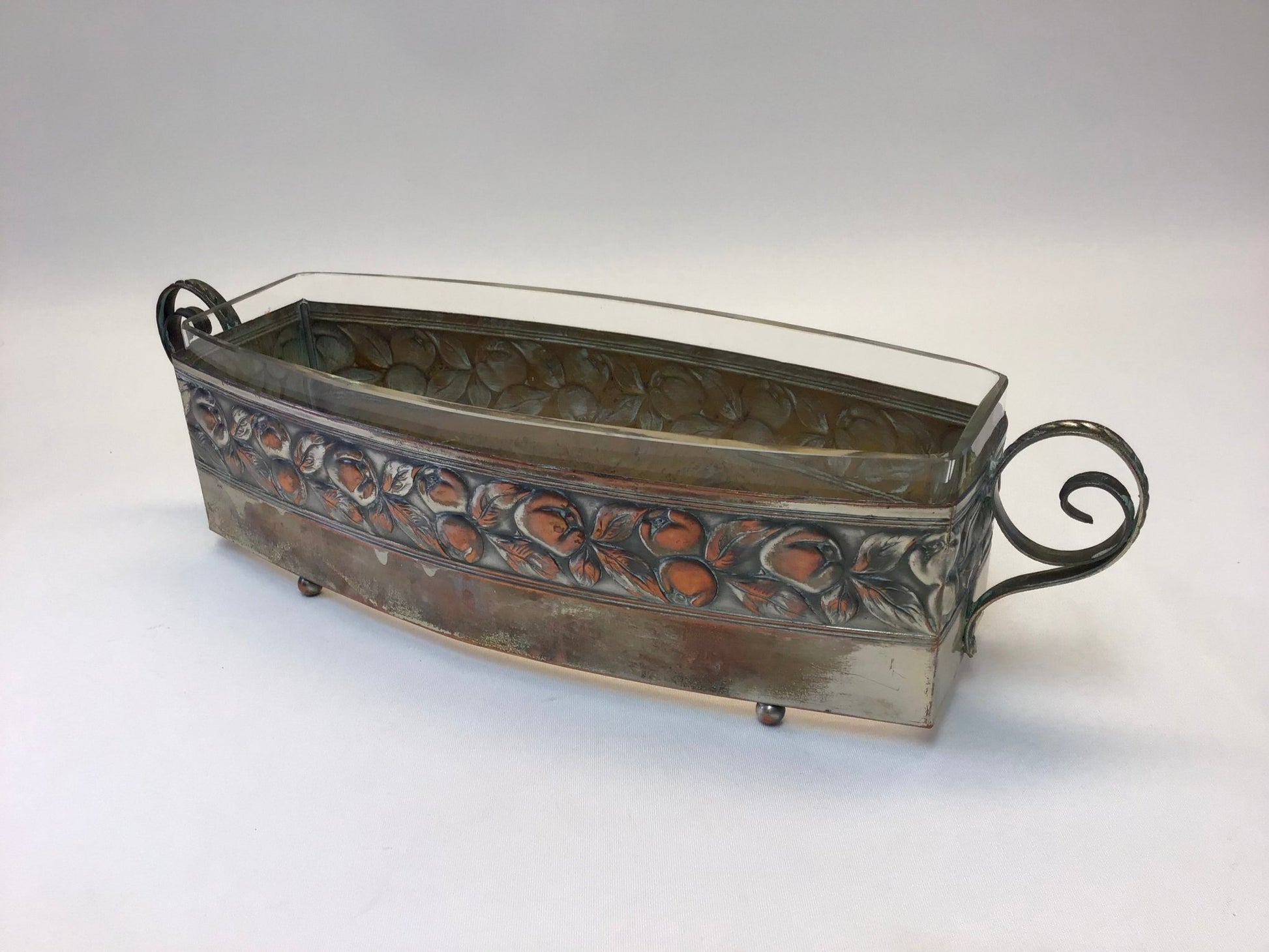 Decorative metal planter with glass top on a white background