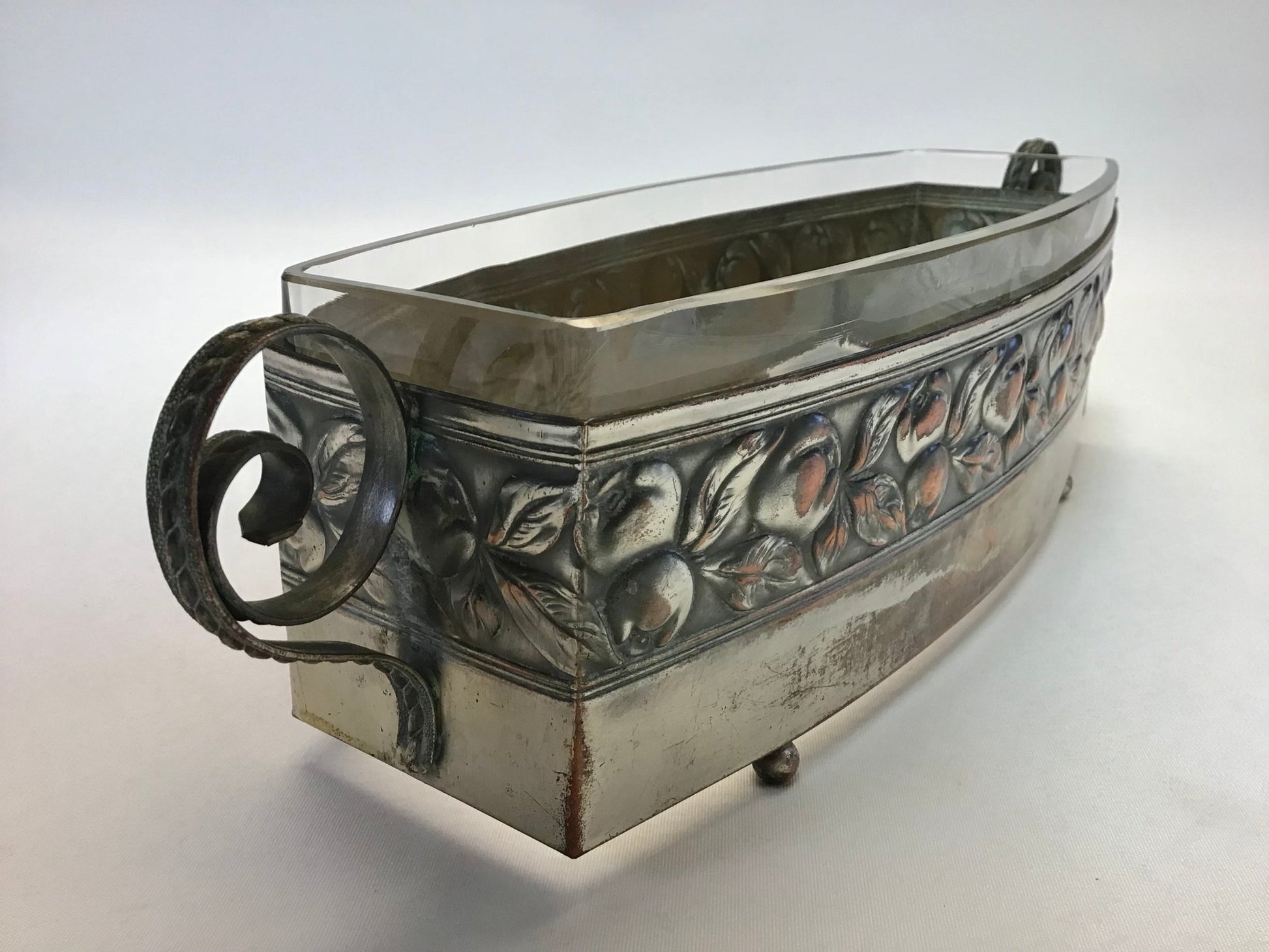 Decorative metal container with floral patterns on a white background