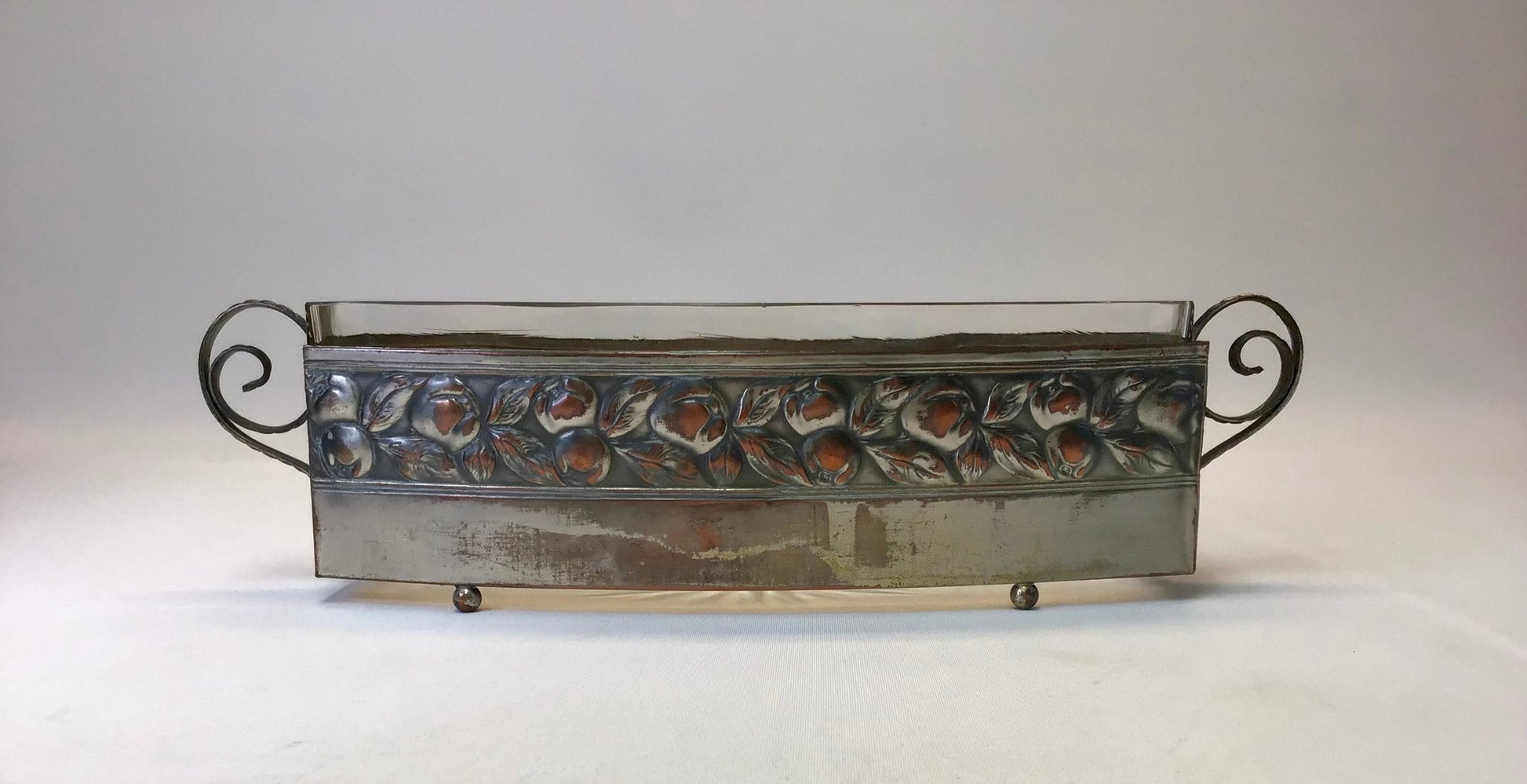 Decorative metal tray with shell pattern on a white background
