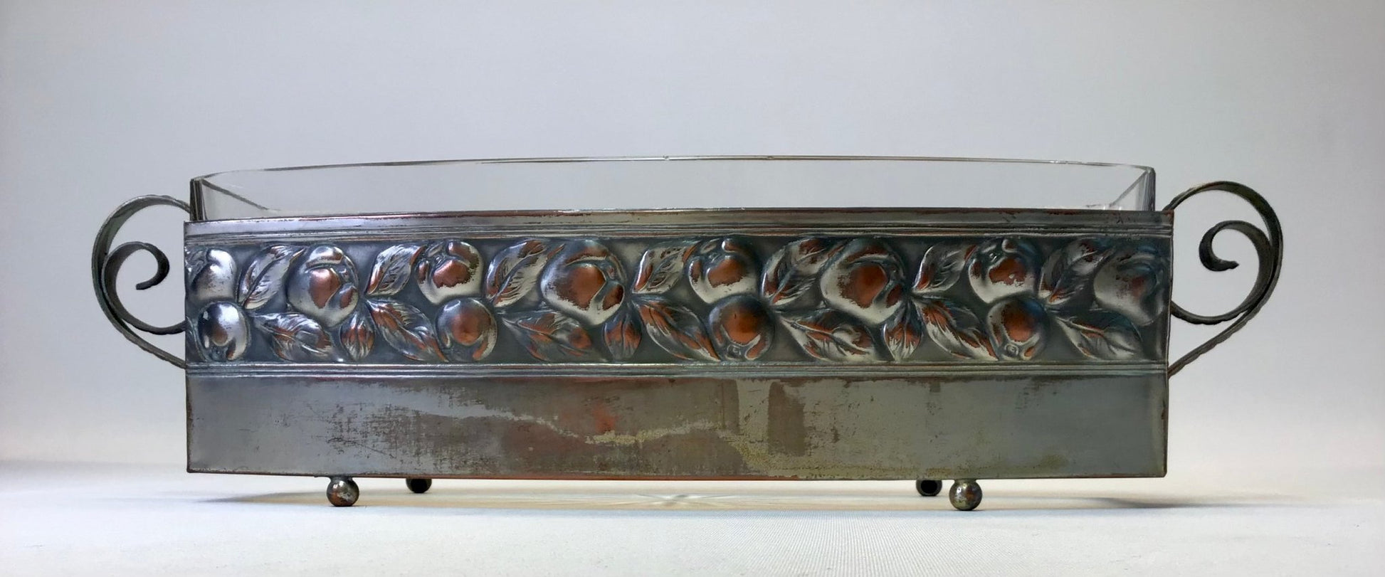 Decorative metal tray with floral patterns on a white background