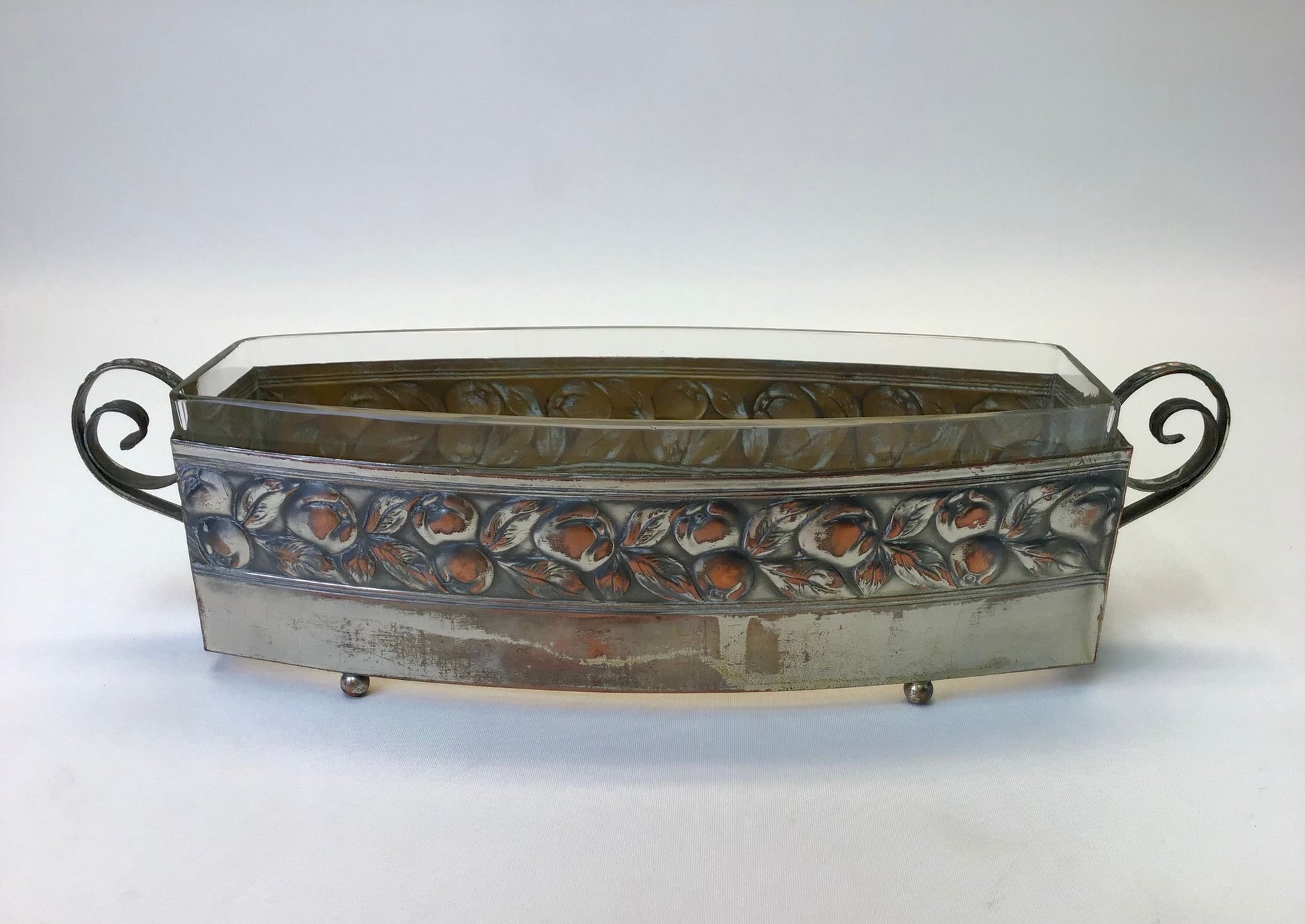 Decorative metal tray with floral patterns on a white background