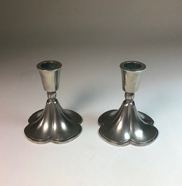 Two silver candle holders on a white background