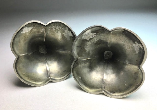 Pair of silver flower-shaped objects on a gradient background