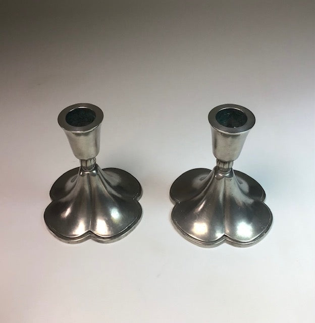 Two silver candle holders on a white background