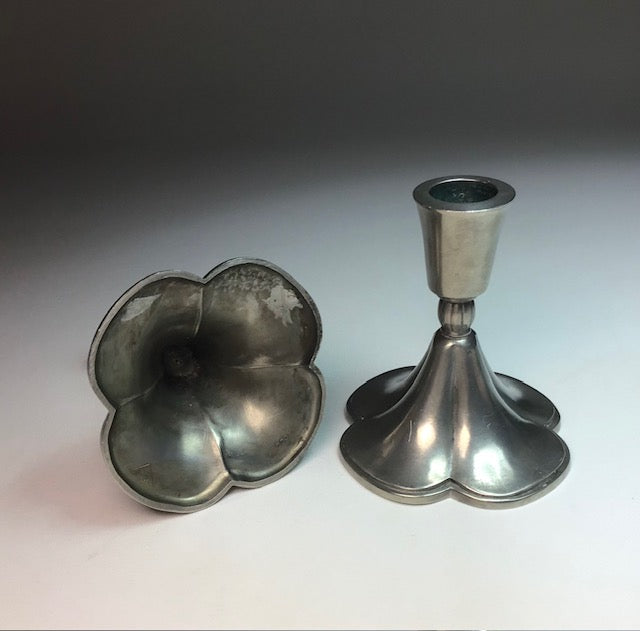 Two metal candle holders on a gradient background
