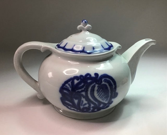 Ceramic teapot with blue floral patterns on a neutral background