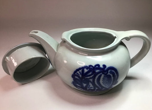 Ceramic teapot with blue floral design on a plain background