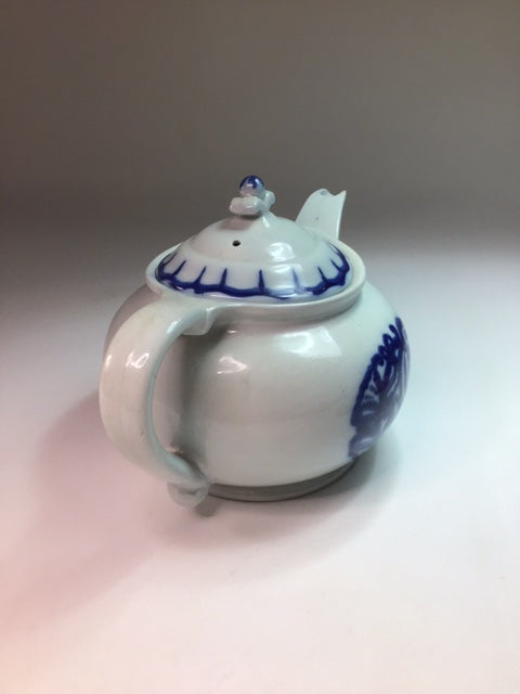 White ceramic jar with blue floral patterns on a neutral background