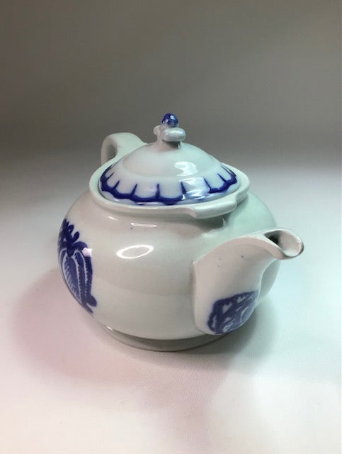 White teapot with blue floral patterns on a white background