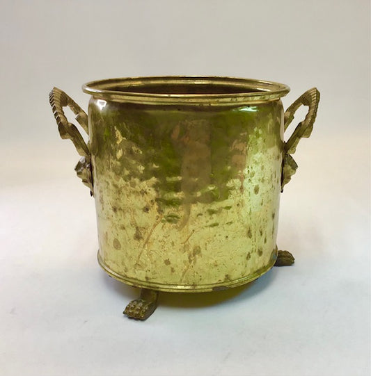 Brass planter with handles and feet on a white background