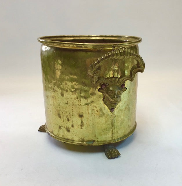 Decorative brass container with intricate designs on a white background