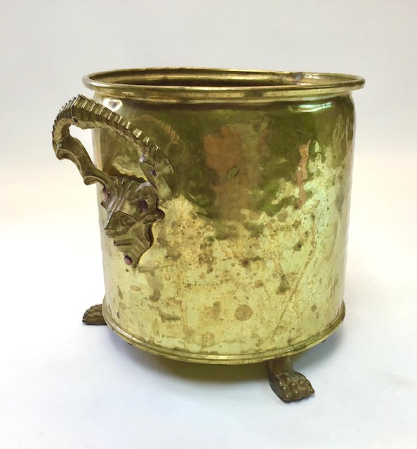 Brass container with decorative handle on a white background