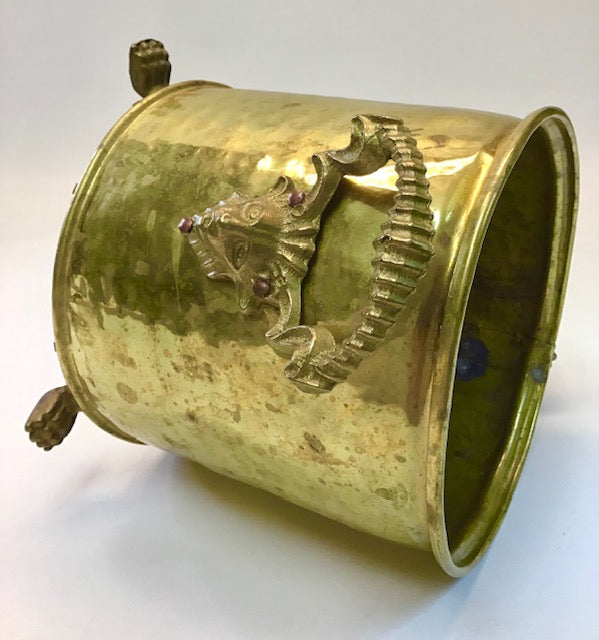 Gold-colored container with a seahorse design on a white background