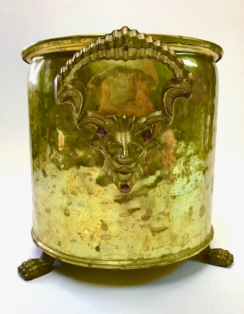 Decorative metal container with a face design on a white background