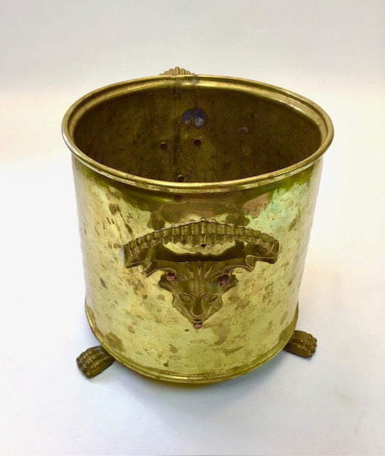 Brass wastebasket with animal emblem on a white background