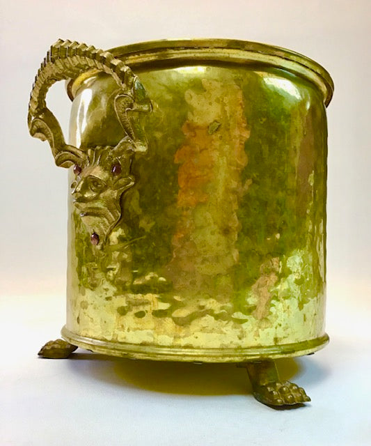 Gold-colored metal container with dragon handle and feet on a white background