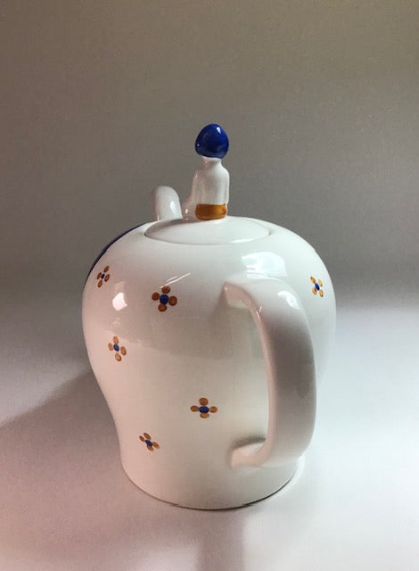 White ceramic teapot with decorative elements on a plain background