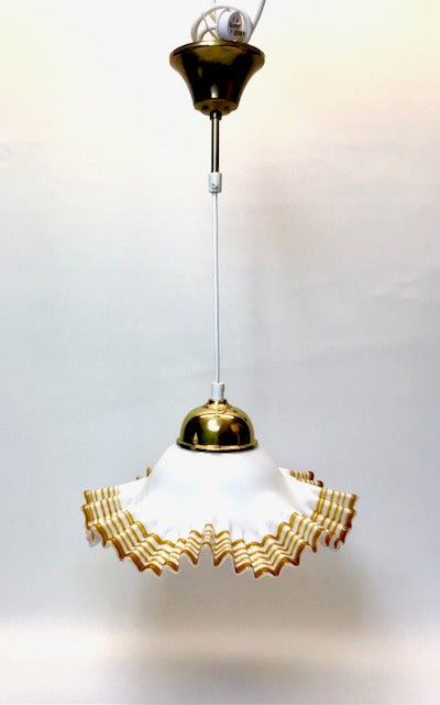 Decorative pendant light with gold and white design on a plain background