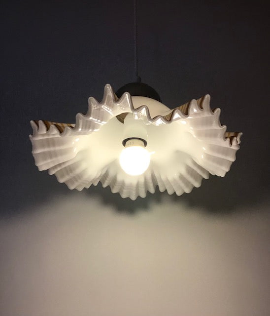 Light fixture with gear-like design on a dark background