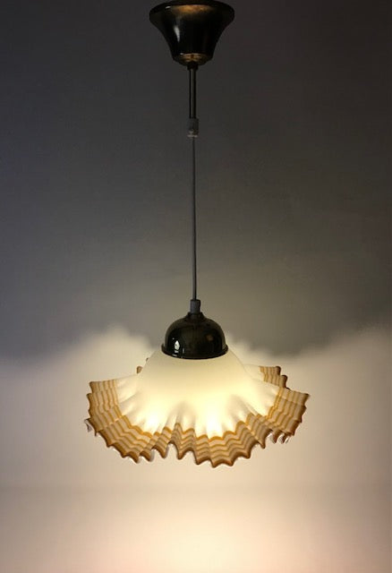 Vintage-style pendant light with a textured glass shade on a dark background