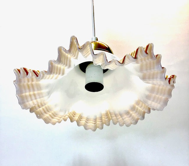 Shell-shaped pendant light on a white background
