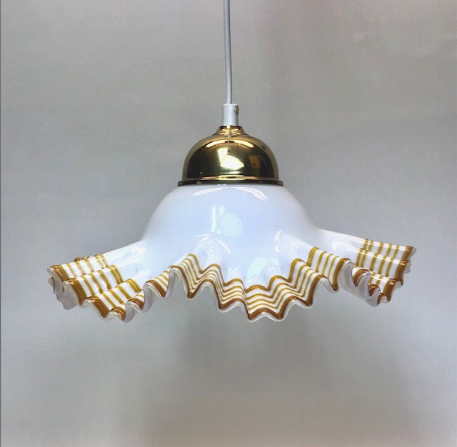 Pendant light with white glass shade and gold decorative rim on a plain background