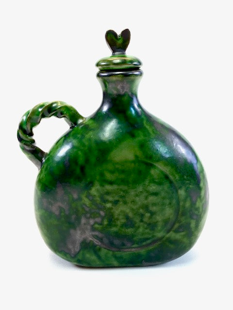 Green ceramic jar with lid on a white background