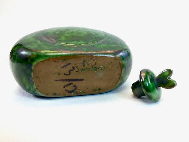 Green ceramic container with lid on a white background