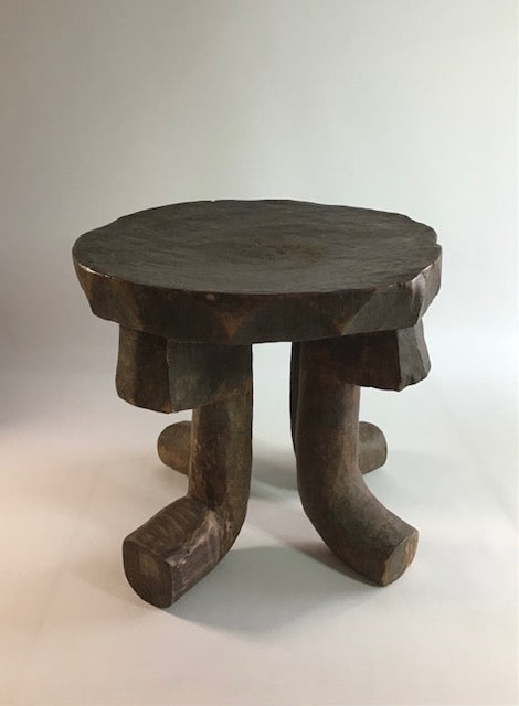 Wooden stool with a round top and four legs on a white background