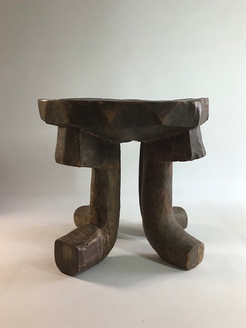 Wooden stool with a unique design on a plain background