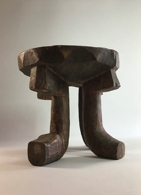 Wooden stool with a unique design on a plain background
