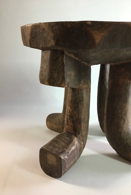 Wooden stool with a rustic design on a plain background