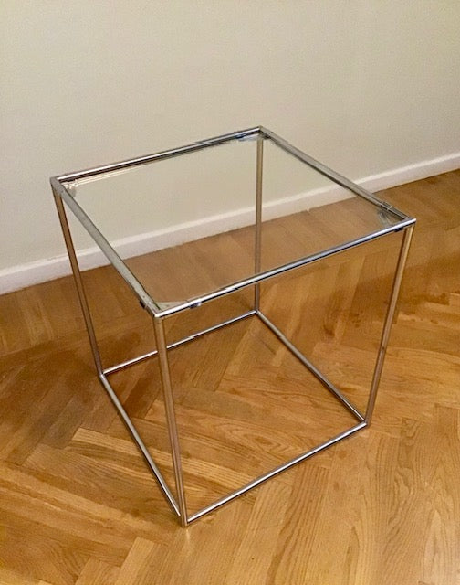 Small glass table with metal frame on a wooden floor