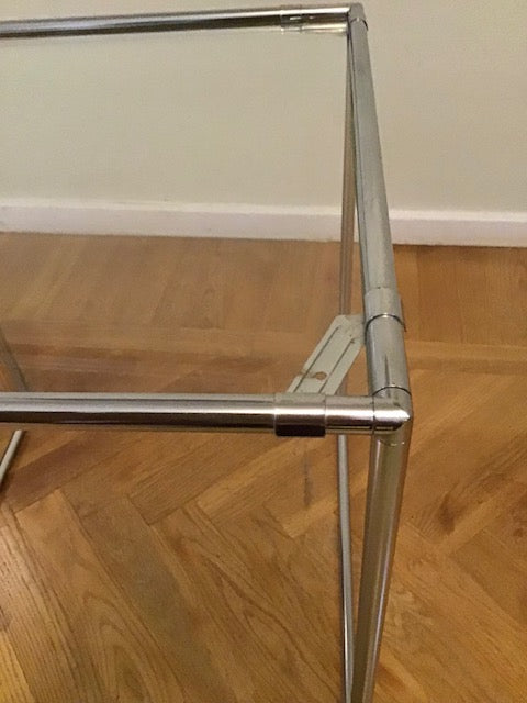Glass table with metal frame on a wooden floor