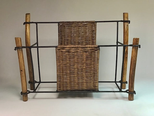 Wicker magazine rack with wooden legs on a plain background