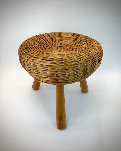 Wicker stool with three legs on a white background