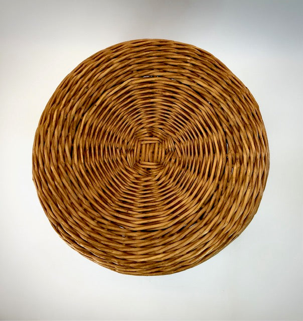 Round woven placemat on a light gray background