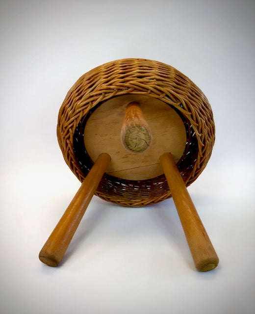 Wicker basket with wooden sticks on a white background