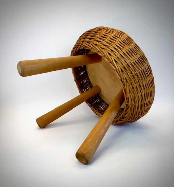 Wicker stool with wooden legs on a white background