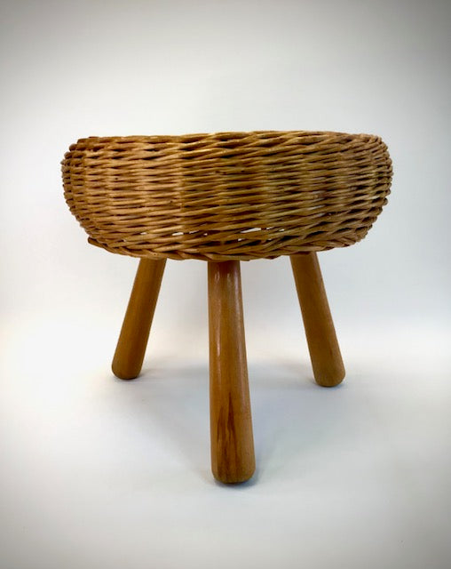 Wicker stool with three legs on a white background